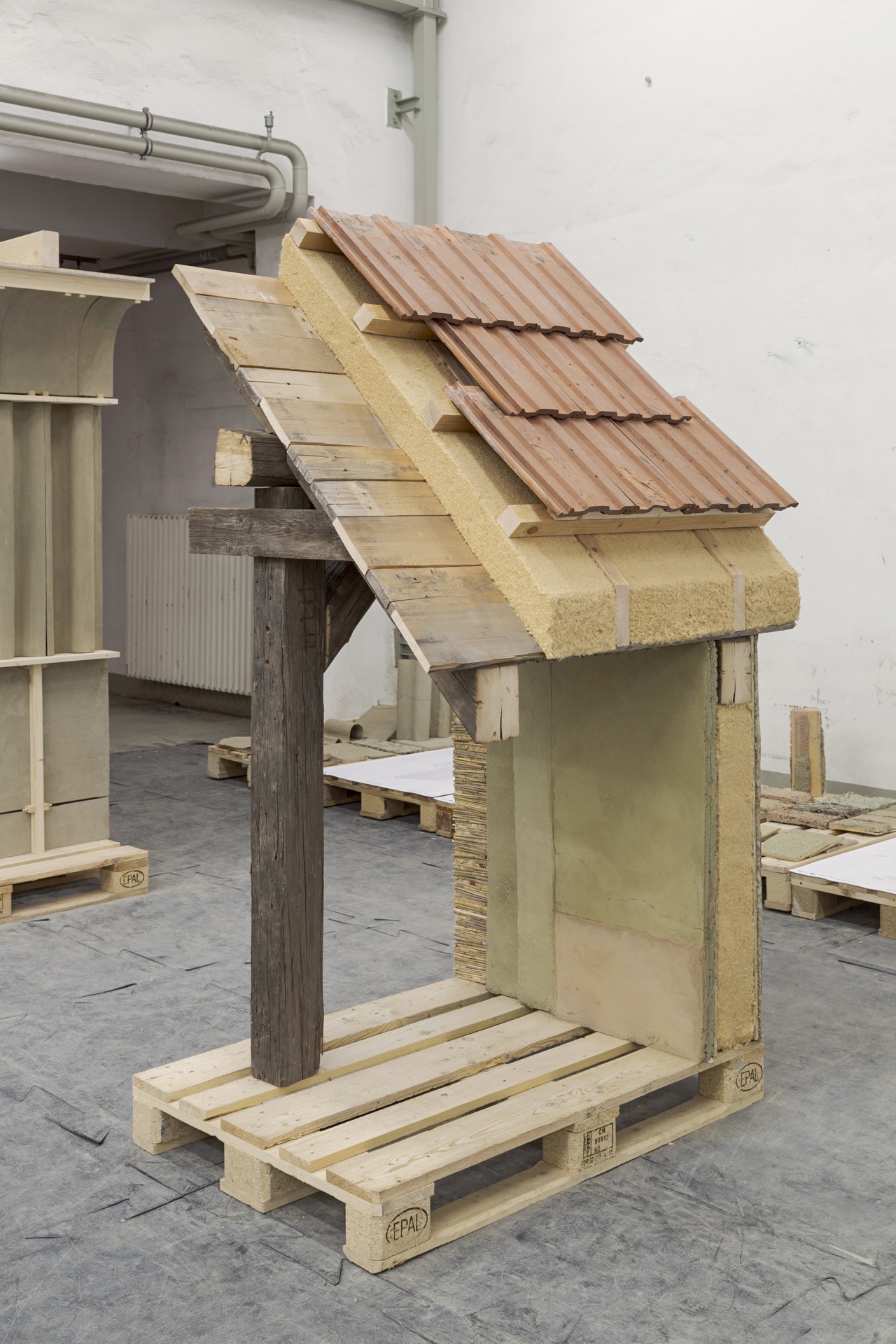 The prototype with its tiled roof, standing on pallets